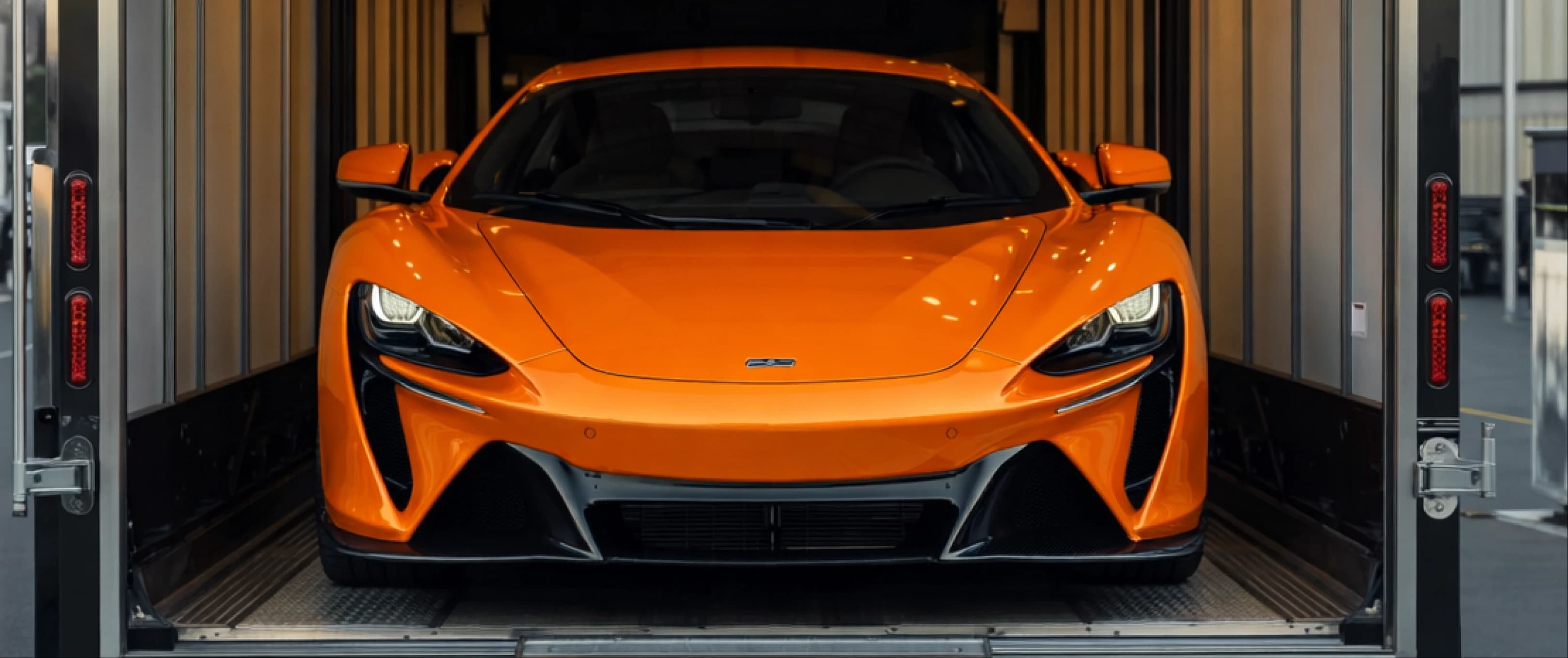Orange McLaren Artura in enclosed transport trailer
